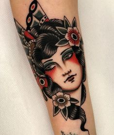 a woman's face with flowers in her hair and an arrow on her arm