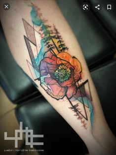 a watercolor tattoo with flowers and arrows on the leg, done by artist mark taylor