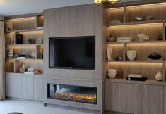 a living room filled with furniture and a flat screen tv mounted on a wall next to a fire place