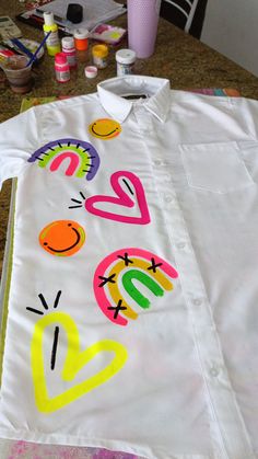 a white shirt with the words love painted on it sitting on top of a table