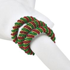 a red and green bracelet on top of a white glove