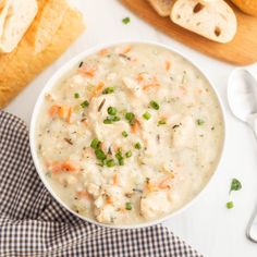 a white bowl filled with soup next to bread