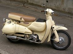 a white motorcycle parked on the street next to a curb with no people around it