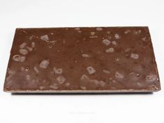 a bar of chocolate on a white surface with drops of water all over the top