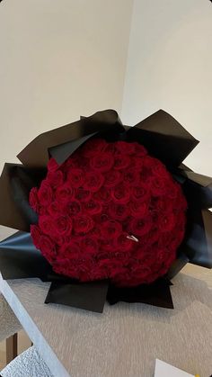 a large bouquet of red roses sitting on top of a table