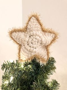 a crocheted star decoration on top of a christmas tree