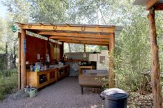 an outdoor kitchen and grill area in the woods