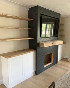 a living room with some shelves and a tv on top of a fireplace mantel