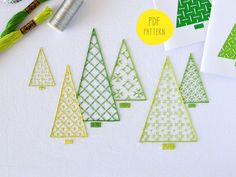 some green and yellow christmas trees are next to thread