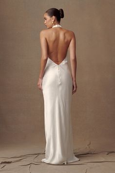 a woman in a white dress looking back