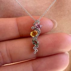 Materials: 18k White Gold Gemstone: Genuine Yellow Sapphire, Green Sapphire, Pink Sapphire, and Diamonds Total Multi-Color Sapphire Carat Weight: 3 sapphires totaling 0.85 ct. Total Diamond Carat Weight: 16 diamonds = 0.14 ct.  Pendant Diameter: 21mm x 6mm Diamond Clarity: SI 1-2 Diamond Color: G-H color Description: This listing is for the pendant only, the necklace is not included. These are genuine gemstones and diamonds, not lab grown An elegant pendant with pink sapphire, green sapphire, and yellow sapphire. Diamonds are elegantly placed around the sapphires to give that extra sparkle. A unique design for everyday wear or for a night out. This beautiful piece will not tarnish in the shower and will not irritate the skin. It will arrive in a jewelry box, with a jewelry bag for travelin Elegant Sapphire Multi-stone Necklace, Multicolor Diamond Necklaces For Anniversary, Sapphire Multi-stone Diamond Gemstones, Fine Jewelry Diamond Pendant Gemstones, Sapphire Stones White Gold Jewelry, Sapphire Jewelry With Stones In White Gold, White Gold Sapphire Jewelry With Stones, Sapphire Pendant Gemstone For Anniversary, Sapphire Multi-stone Necklace As A Gift