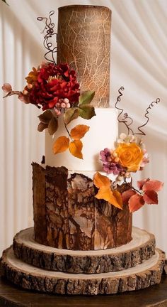 a three tiered cake decorated with flowers and leaves