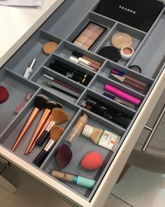 an open drawer with makeup and brushes on it