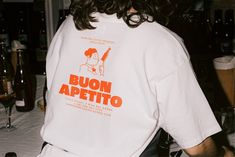 a man with long hair wearing a t - shirt that says buon apettio