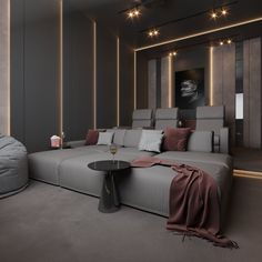 a living room filled with grey couches and pillows next to a round coffee table