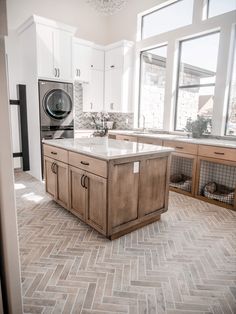 a kitchen with an island in the middle and a washing machine on the other side