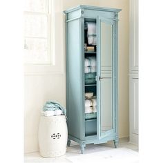 a tall blue cabinet sitting next to a window