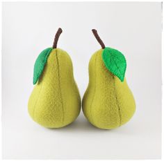 two yellow pears with green leaves on them