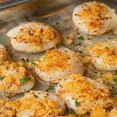 cooked scallops with parmesan cheese and herbs in a baking pan, ready to be eaten