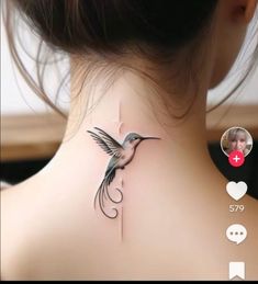 the back of a woman's neck with a bird tattoo on it