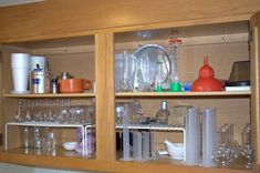 the shelves are filled with glassware and other kitchen items, such as cups, saucers, spoons, etc