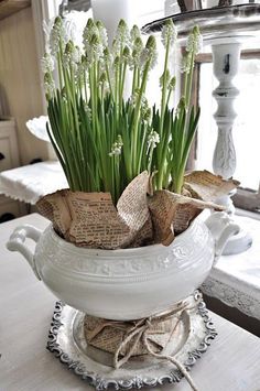 a white vase filled with flowers on top of a table