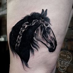 a black and white horse tattoo on the thigh