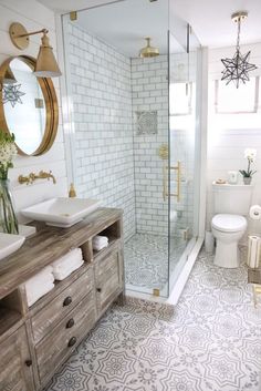 a bathroom with a sink, toilet and walk in shower next to a wooden dresser