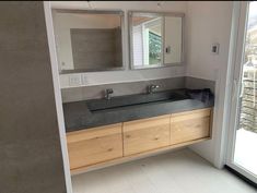 a bathroom with double sinks and large mirrors on the wall next to sliding glass doors