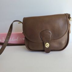 "Vtg classic coach Saddlery Bag Soft and supple Putty leather with brass hardware Roomy interior with zip pocket, outer slip pocket covered by a flap and secured with a turnlock. Adjustable strap with a 14 1/2\"-21\" drop Measures: 9 1/2\"L, 9\"H, 4\"W Hang tag and chain Made in New York City, USA #616-5834 Cleaned, conditioned and ready to wear! More vtg coach styles/colors available Questions? Just ask G38" Leather Key, Coach Leather, Vintage Coach, Retro Vibe, Saddle Bags, Coach Bags, Purses And Handbags, Shoulder Bags, Zip Pockets