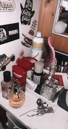 there are many different items on the counter in this room, including perfume bottles and hairbrushes