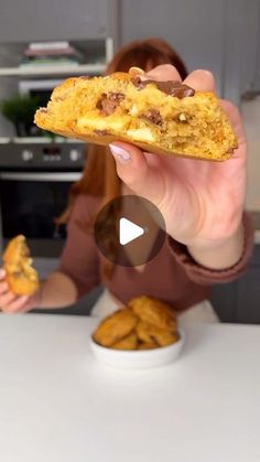 a woman holding up a cookie in front of her face