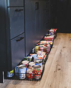 the food is lined up on the floor next to the refrigerator