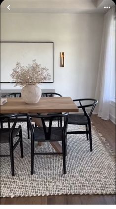 a dining room table with chairs and a vase on it