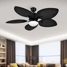 a living room with couches, tables and a ceiling fan in the middle of it