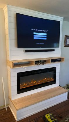 a flat screen tv mounted on top of a fireplace