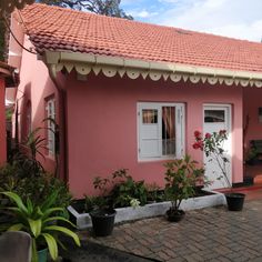 a pink house with potted plants in front of it