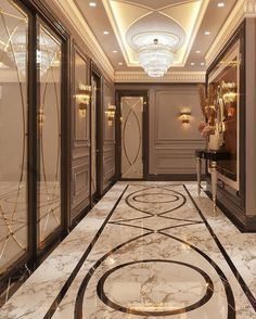 an elegant hallway with marble floors and chandeliers on either side of the doors