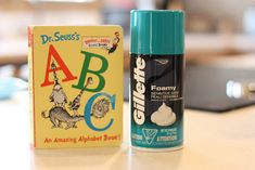 a bottle of glue next to a children's abc book on a counter top