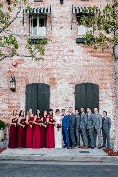 a group of people standing next to each other in front of a tall brick building