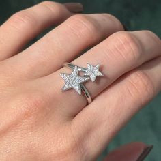 a woman's hand with a ring on it and two stars in the middle