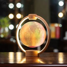 an illuminated object sitting on top of a wooden table in front of a blurry background