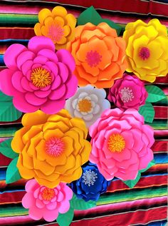 colorful paper flowers are arranged in an arrangement