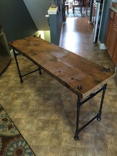 a wooden table sitting on top of a kitchen floor