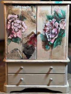 an old dresser has flowers painted on it