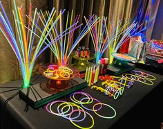 a table topped with lots of neon colored sticks