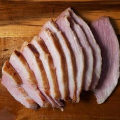 sliced ham sitting on top of a wooden cutting board