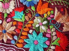 an embroidered cloth with flowers and leaves on it