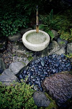 a stone sink in the middle of some rocks