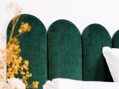 a green headboard with white pillows and flowers